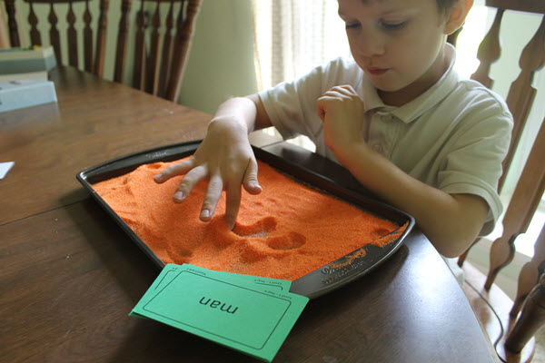 child practicing sight words with a salt tray