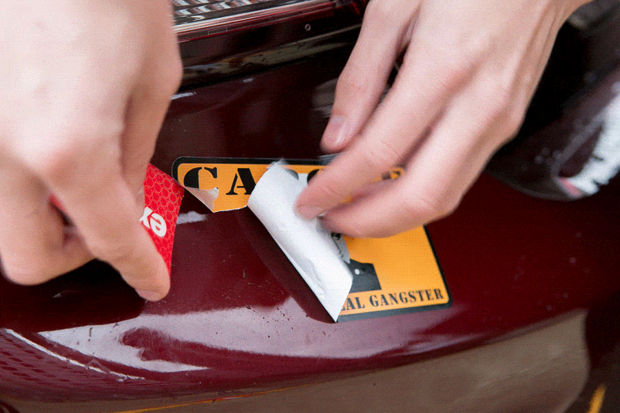 Peeling a sticker off a car
