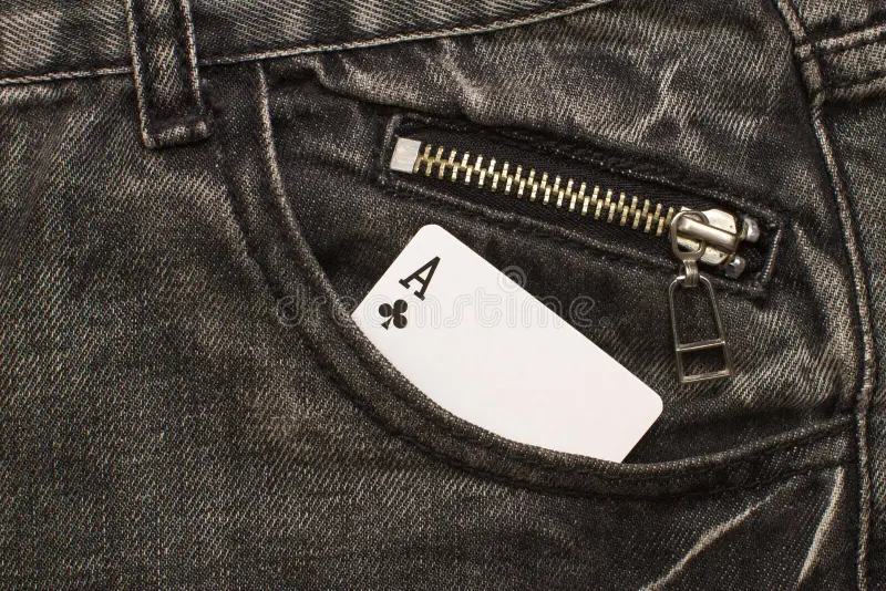 Ace card inside gray jeans pocket with zip lock. Closeup royalty free stock photography