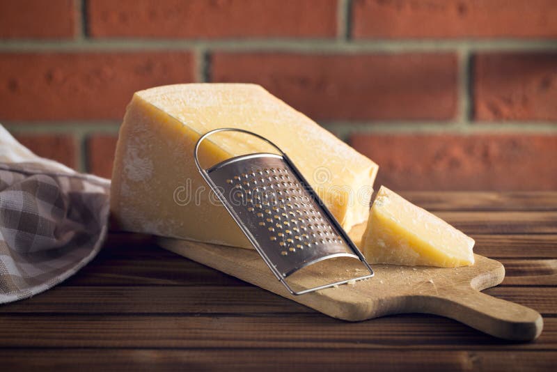 Cheese grater and parmesan. The cheese grater and parmesan stock photos