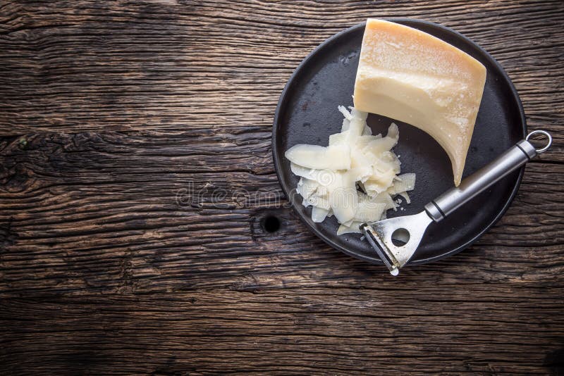 Cheese Parmesan . Parmesan cheese on old oak table with cheese grater.  stock image