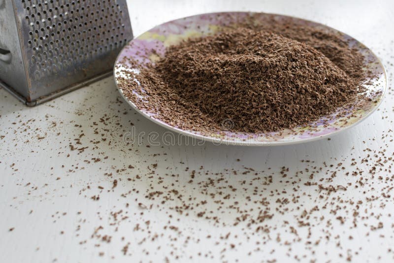 Chocolate grated on a fine grater. Lies on a plate royalty free stock photo