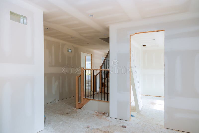 Finishing putty in the room walls plasterboards with room under construction. Walls plasterboards with room under construction with finishing putty in the room royalty free stock photography