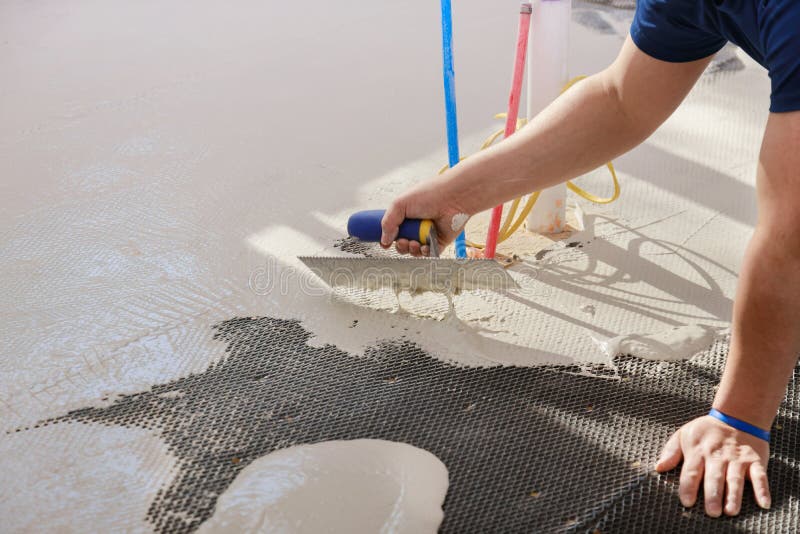 Floor preparation before pouring concrete in troweling adhesive onto a concrete floor. Preparation before pouring concrete in troweling adhesive onto floor a stock image