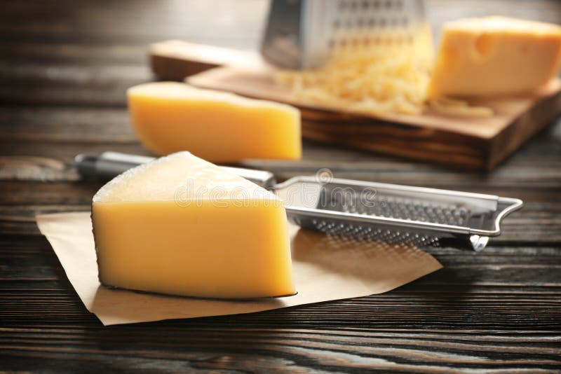 Fresh cheese and grater. On wooden table royalty free stock photography