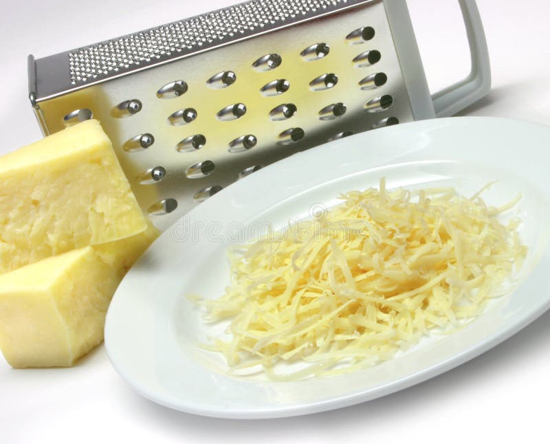 Grated Cheese. Plate with grated cheese, block cheese and grater, photographed on white stock photos