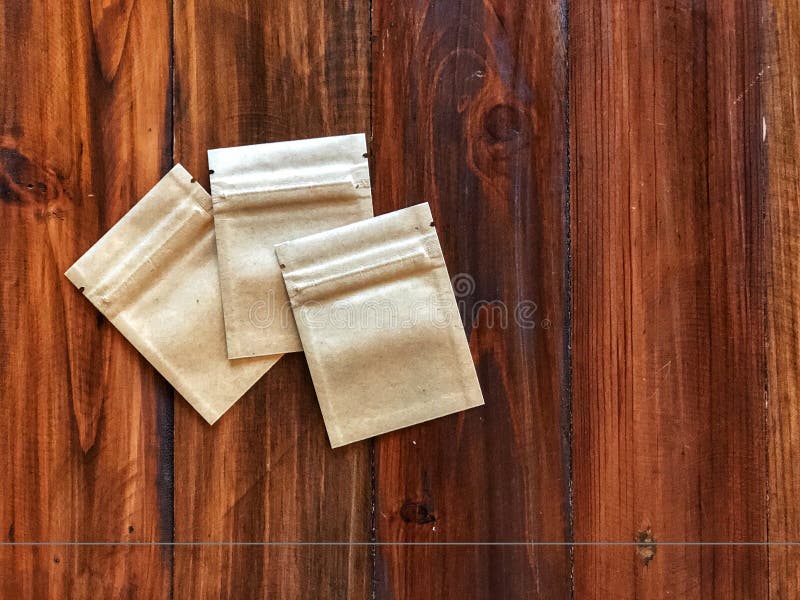 3 Kraft Paper zipper lock bag on the vintage wooden table. Empty packing bag for your product advertisement.Top view and copy space stock photo