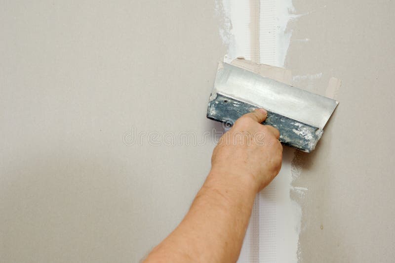 Man putty plasterboard. In domestic room royalty free stock photo