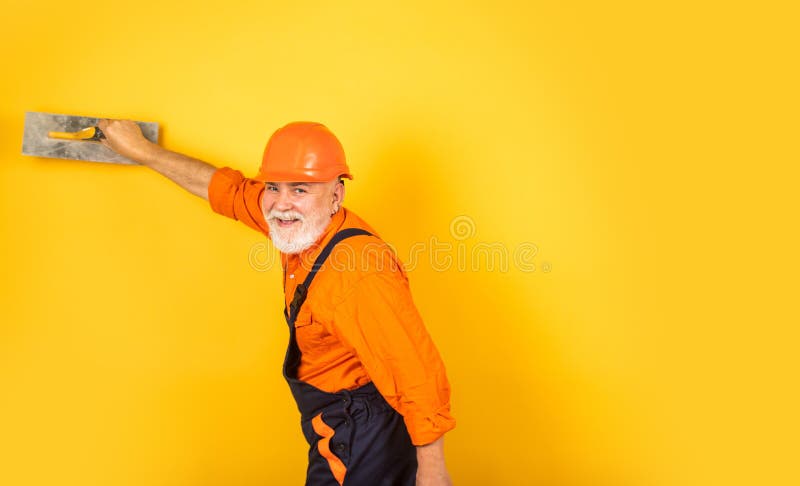 Man with spatula. process of applying layer of putty. Plastering tools for plaster. plaster trowel spatula on yellow. Drywall plasterboard. Plasterer in working royalty free stock photography