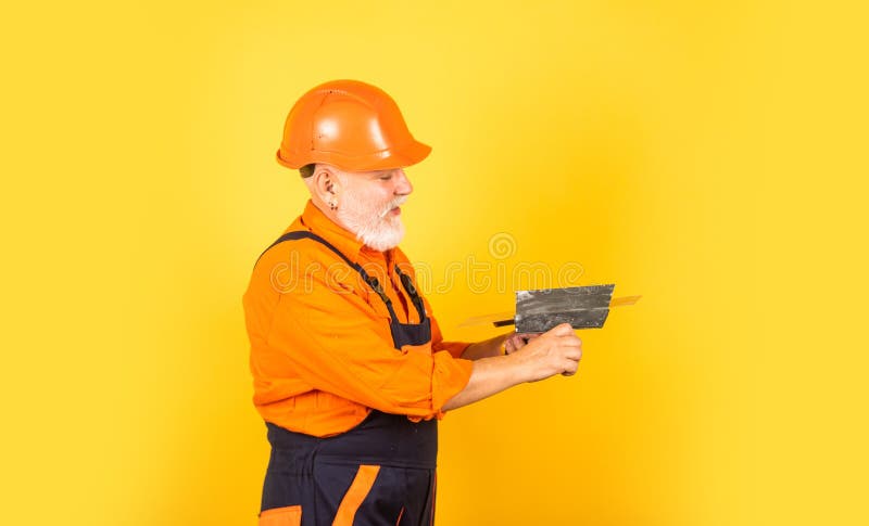 He needs little break. Plasterer in working uniform plastering. man with spatula. process of applying layer of putty. Plastering tools for plaster. plaster stock photography