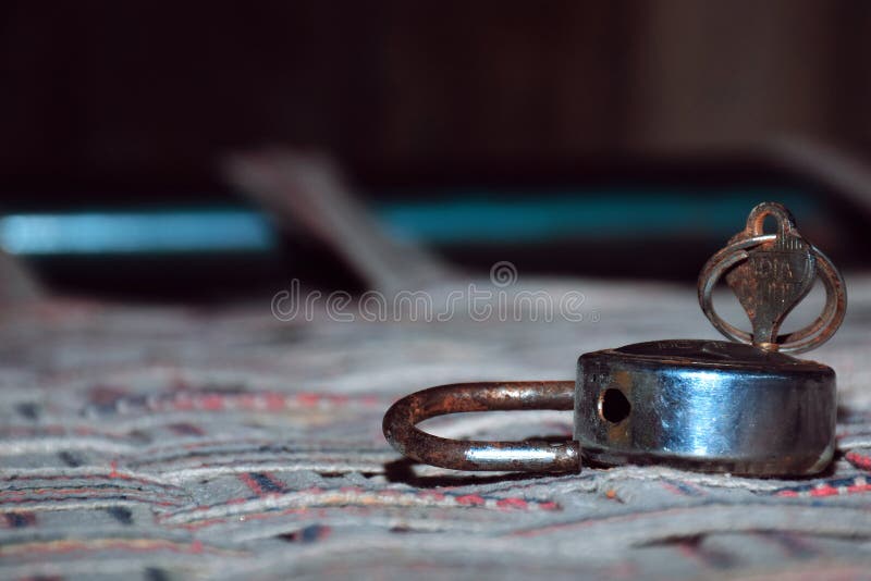 The old lock and key on abed of clothes with blur and black background 1. The old lock and key on abed of clothes with blur and black background stock photography