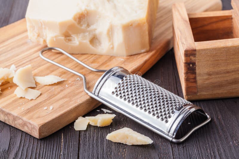 Parmesan cheese. Grated Parmesan cheese and Olive Wood Parmesan Cheese Grater royalty free stock photography