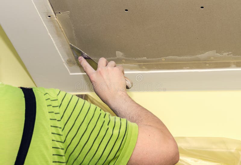 Puttying drywall seams. Builder embeds the joints drywall putty, close-up stock photography