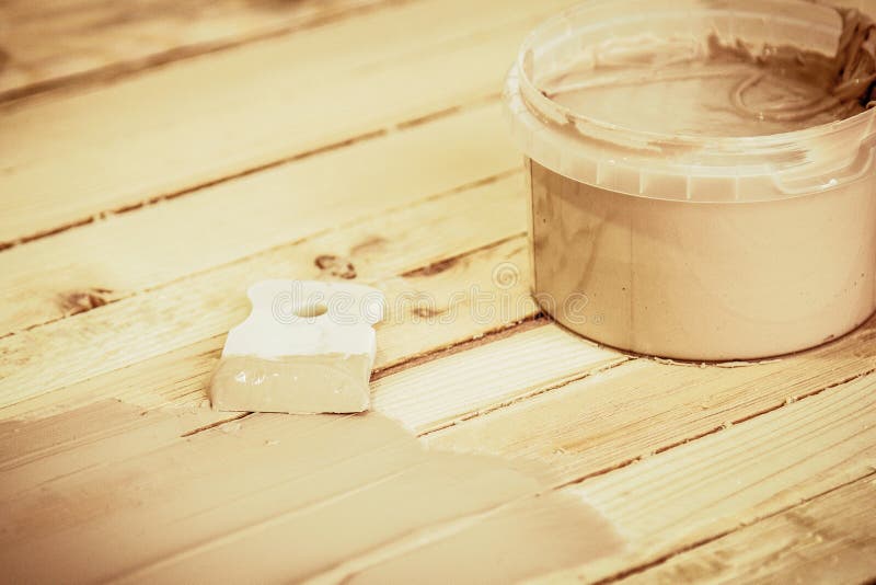 Spatula and putty for puttying wood, on the boards background.  stock images