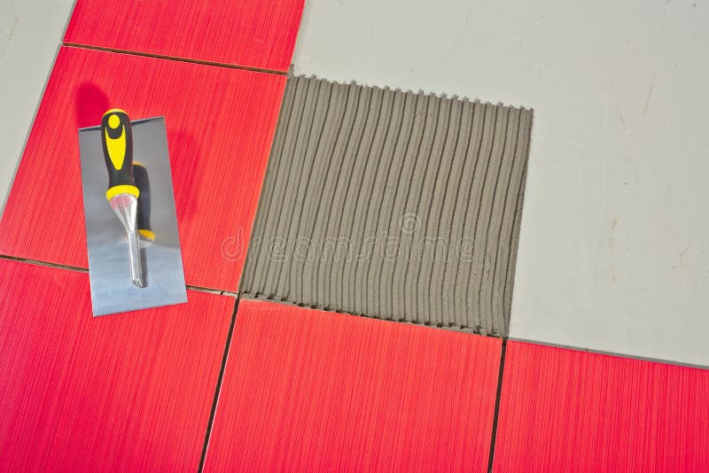 Trowel on red tiles. And tile adhesive stock photos